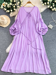 Purple bohemian maxi dress with balloon sleeves, tie neckline, and cinched waist.