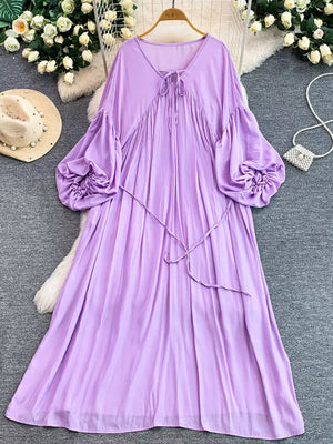 Purple bohemian maxi dress with balloon sleeves, tie neckline, and cinched waist.