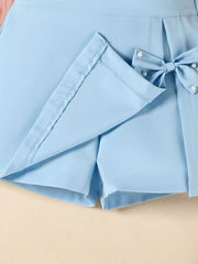 Sky blue skort with pearl-embellished bow detail and neat stitching.
