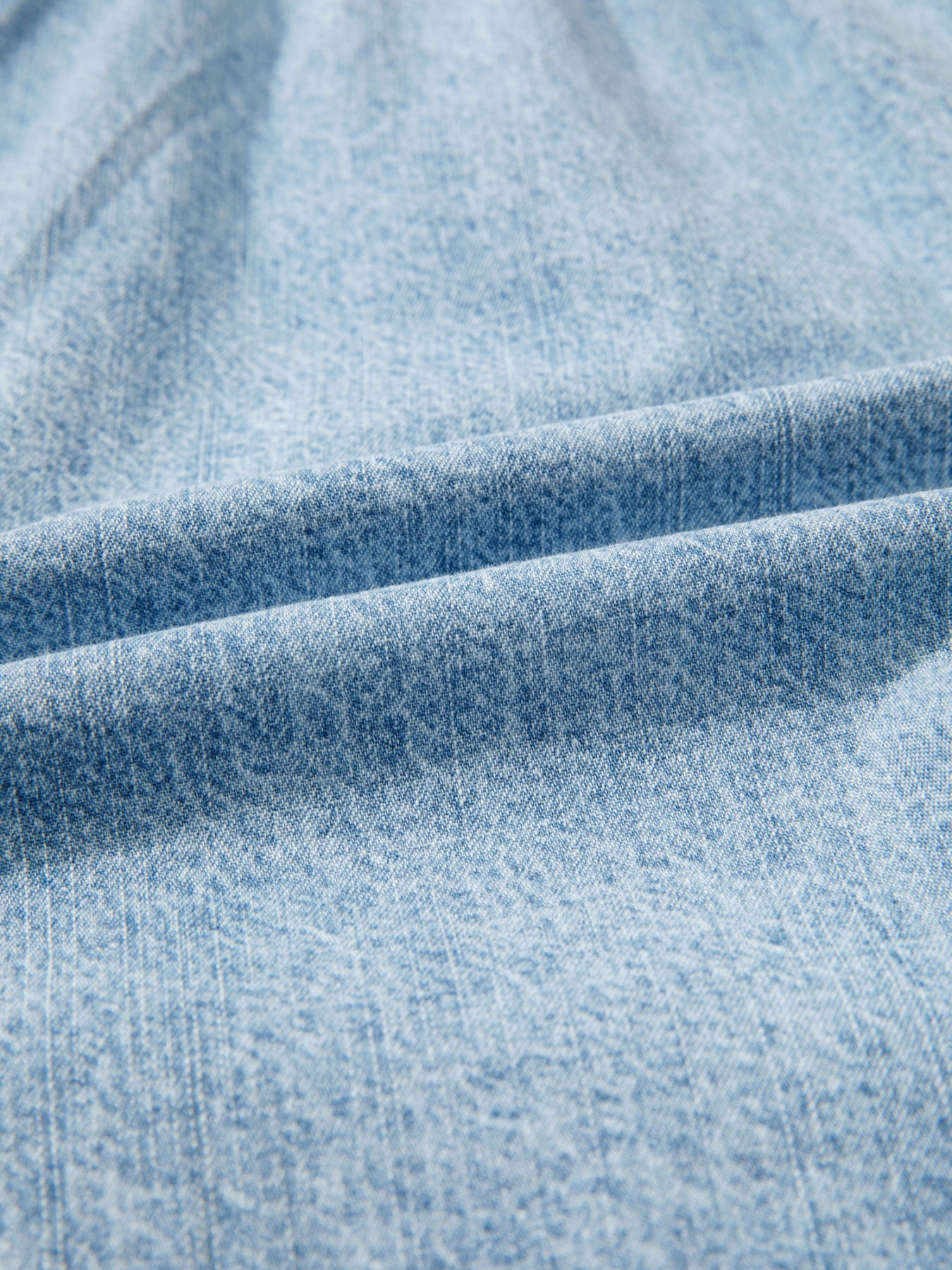 Light wash denim shorts with frayed edges and drawstring detail