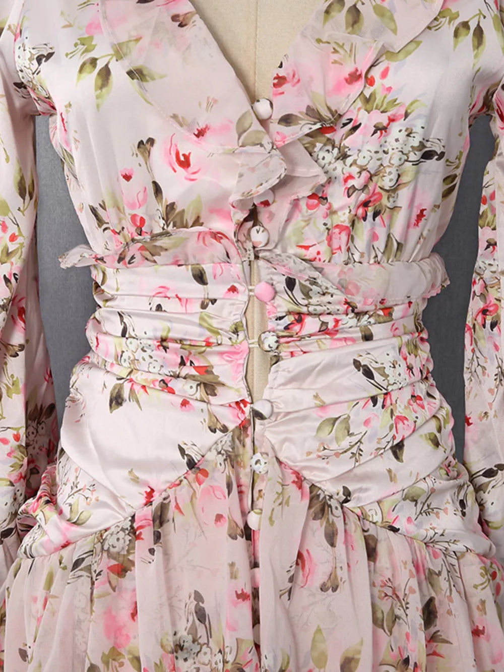 Charming ruffled floral mini dress with buttoned front and ruched waist detail.