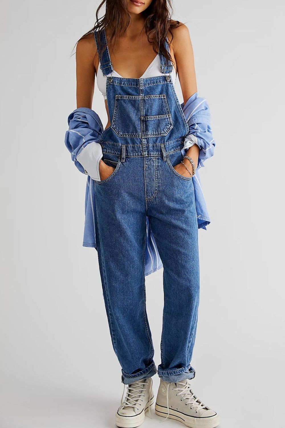 Relaxed fit denim overalls in medium wash cotton with crisscross straps and a bib pocket.