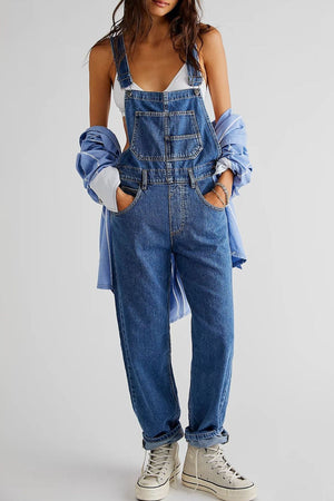 Relaxed fit denim overalls in medium wash cotton with crisscross straps and a bib pocket.