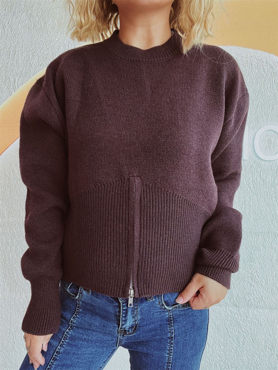 Chocolate zip-front knit sweater with ribbed hemline and mock neck.