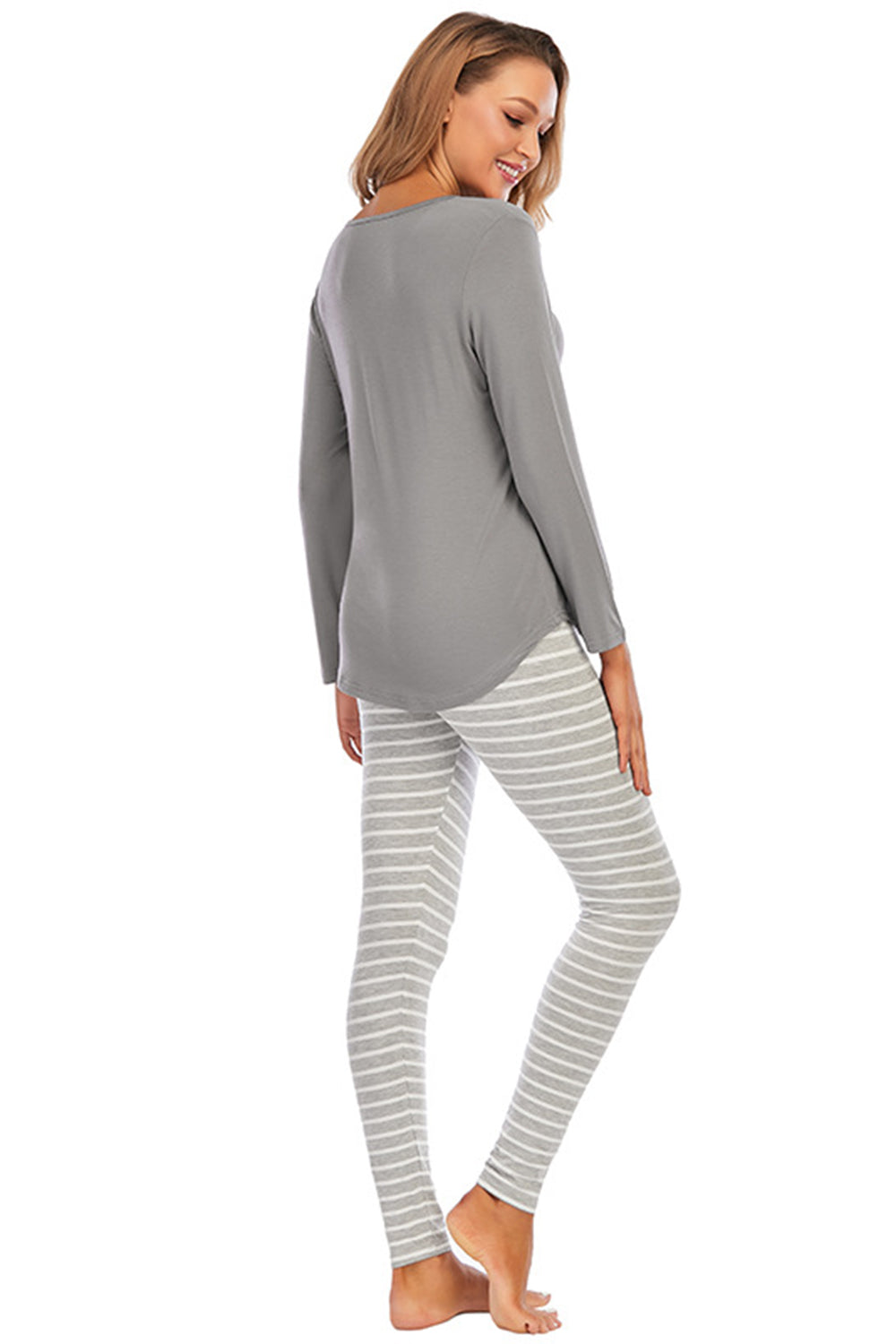 Charcoal long sleeve top and striped lounge pants on a woman.