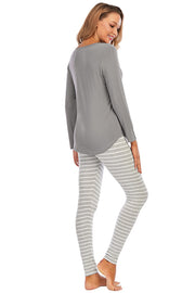 Charcoal long sleeve top and striped lounge pants on a woman.