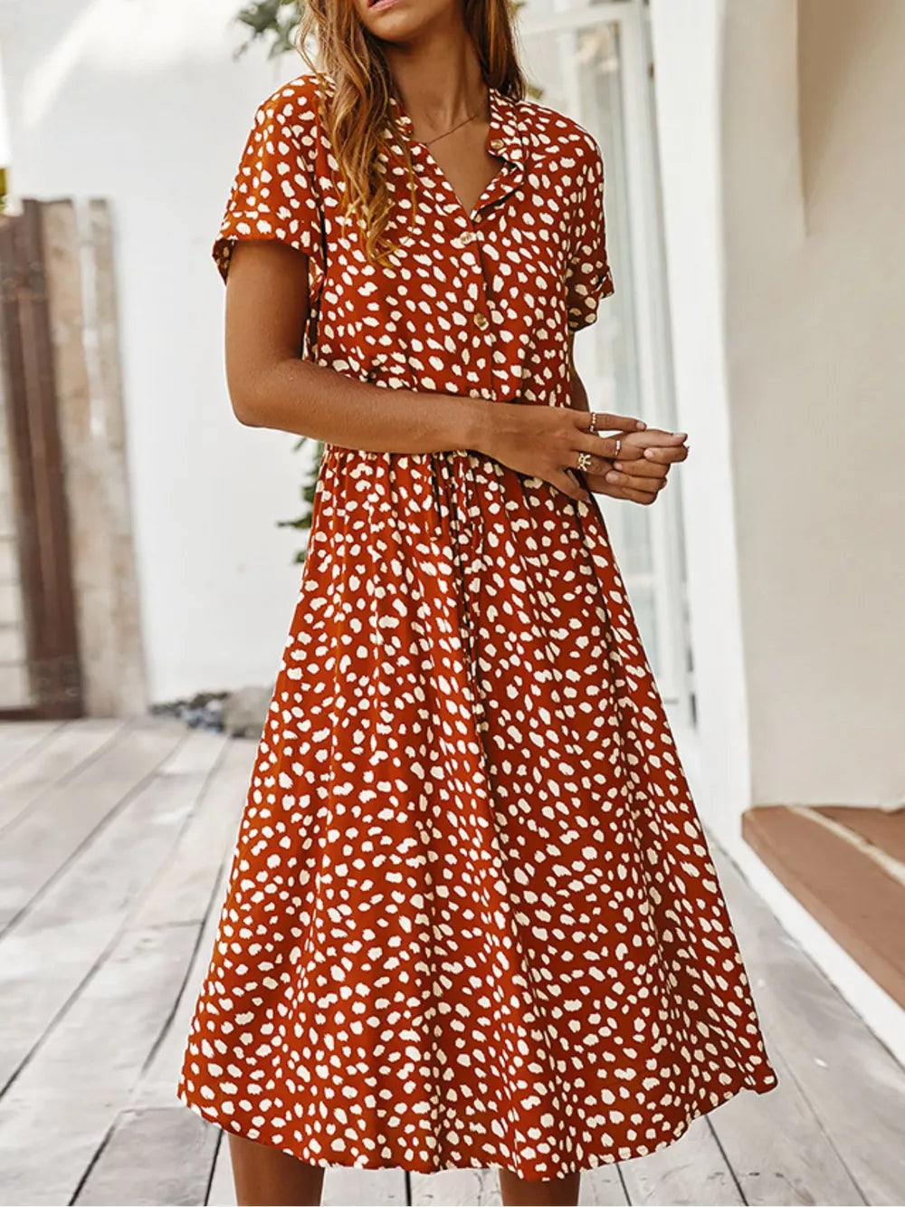 Orange animal print midi dress with tied waist, button-down, short sleeves, and a-line skirt.