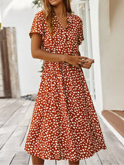Orange animal print midi dress with tied waist, button-down, short sleeves, and a-line skirt.
