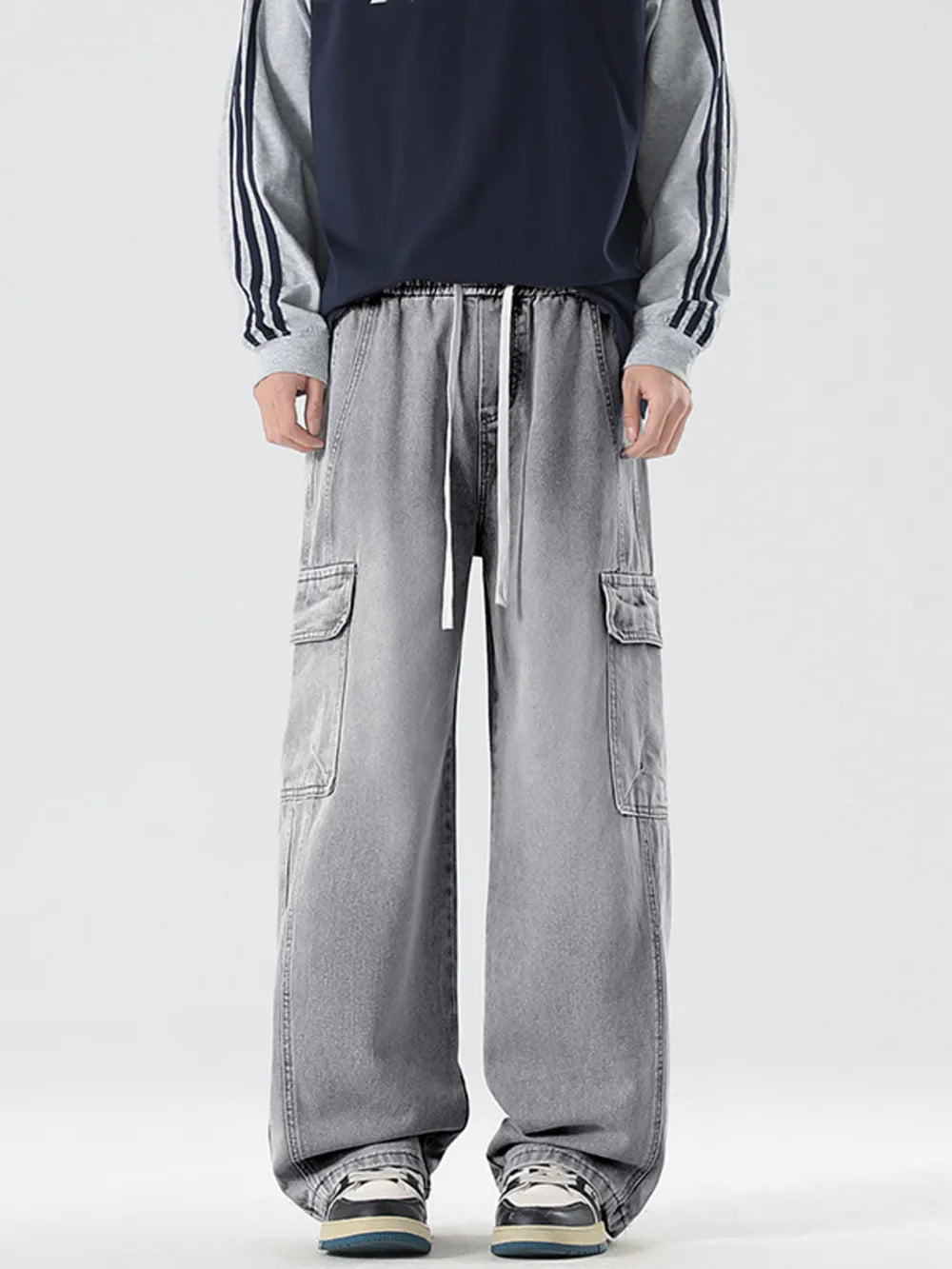 Light gray oversized cargo jeans with drawstring waist and large side pockets.