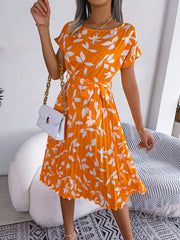 Orange leaf print midi dress with short sleeves, tie waist, and pleated skirt.