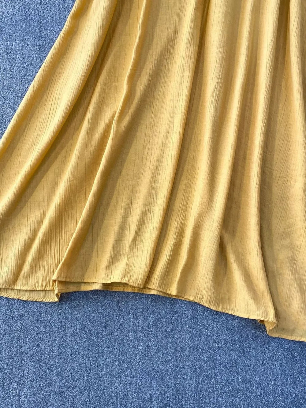 Yellow textured fabric detail of a flowy two-piece set