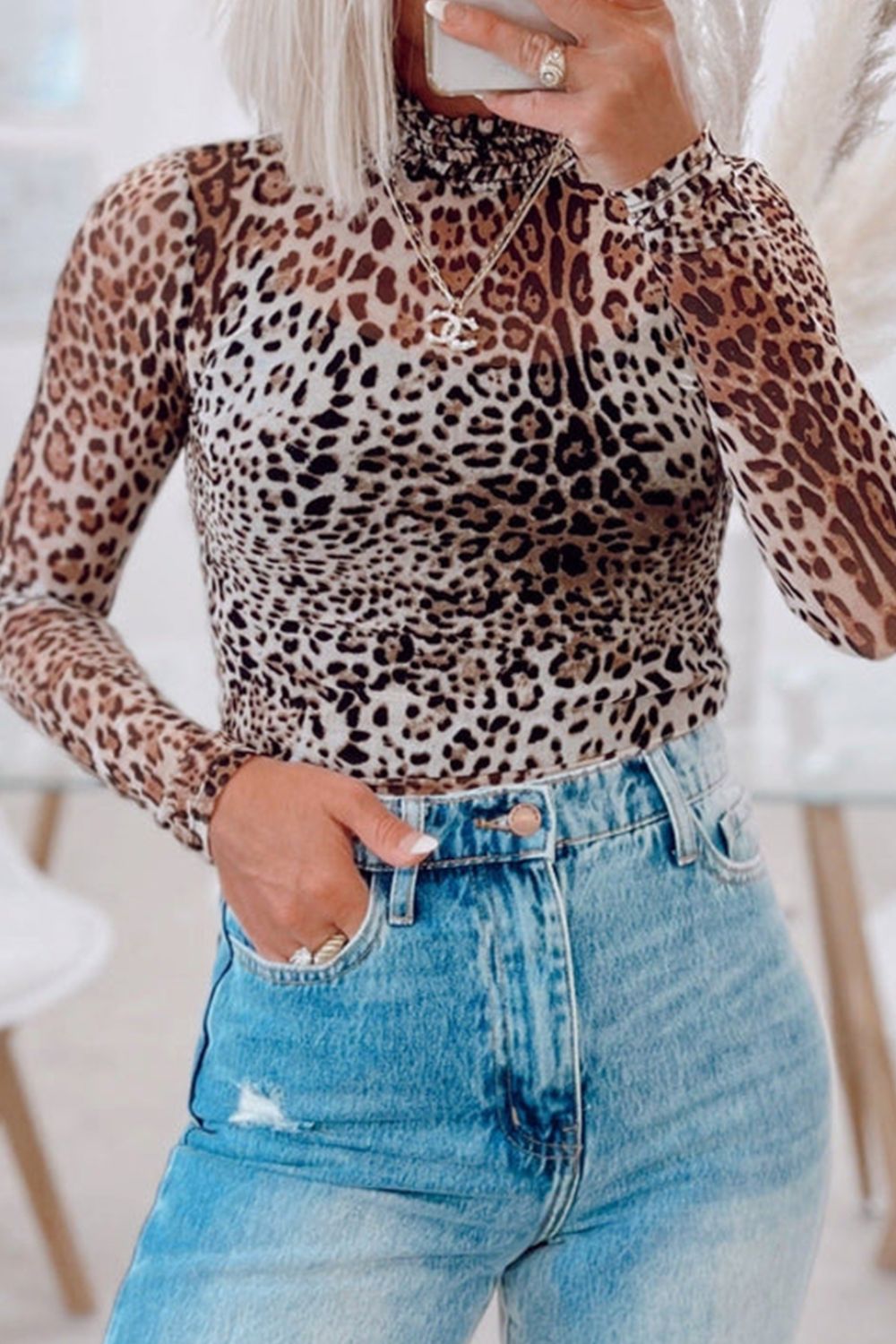 Sheer leopard print turtleneck top with long sleeves and ruffled neckline.