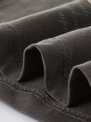 Toddler t-shirt in dark gray cotton with visible stitching and a subtle green graphic print.