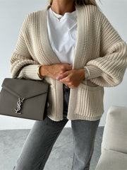 Beige textured puff sleeve cardigan with pockets, styled with a white tee and grey jeans.