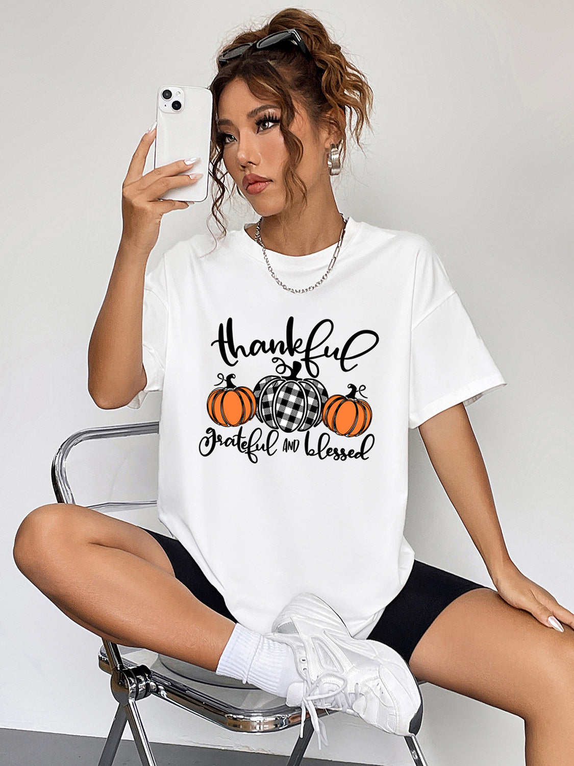 White graphic tee with thankful pumpkins and text, crew neck, short sleeves.
