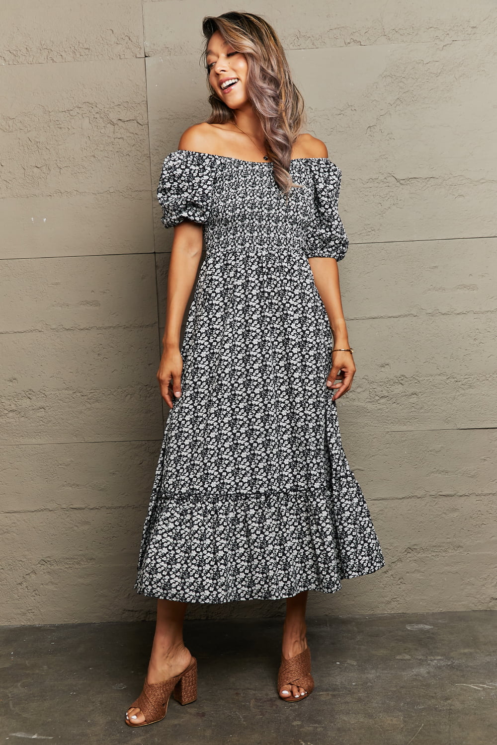 Black floral midi dress with smocked bodice, off-shoulder neckline, puff sleeves, and tiered skirt.