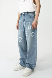Painted script baggy jeans in medium wash denim with white graphic print.