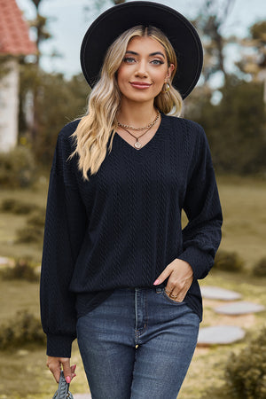 Dark blue cable knit V-neck pullover sweater with textured fabric.