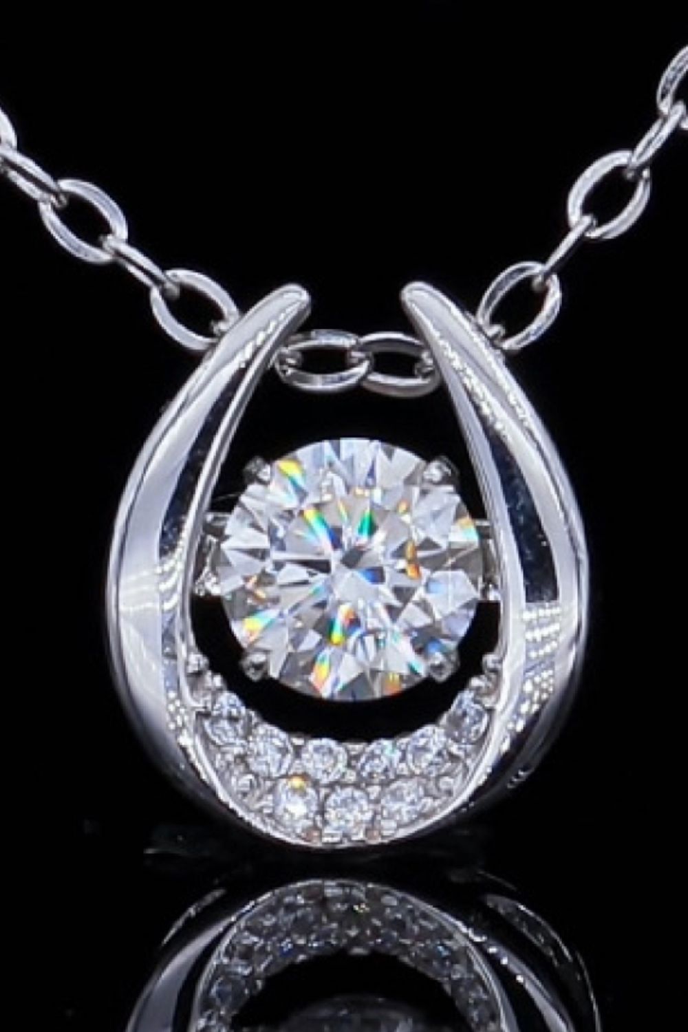 Silver necklace with a central diamond and a halo of smaller diamonds in a horseshoe-shaped pendant.