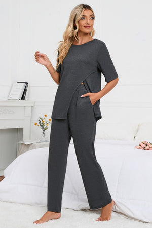 Dark gray loungewear set with asymmetric slit tee and wide leg pants.