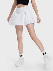 White pleated performance mini skirt with a flared cut