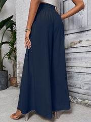 Ruffled waistline palazzo trousers in dark blue with a wide leg and textured fabric.