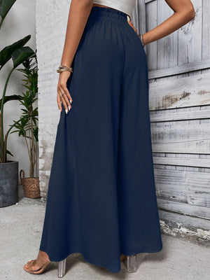 Ruffled waistline palazzo trousers in dark blue with a wide leg and textured fabric.