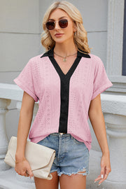 Perforated panel polo top in blush pink with black accents and short sleeves.
