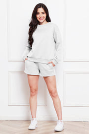 Light gray crewneck sweatshirt and pocket shorts loungewear set on a woman.