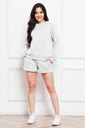 Light gray crewneck sweatshirt and pocket shorts loungewear set on a woman.