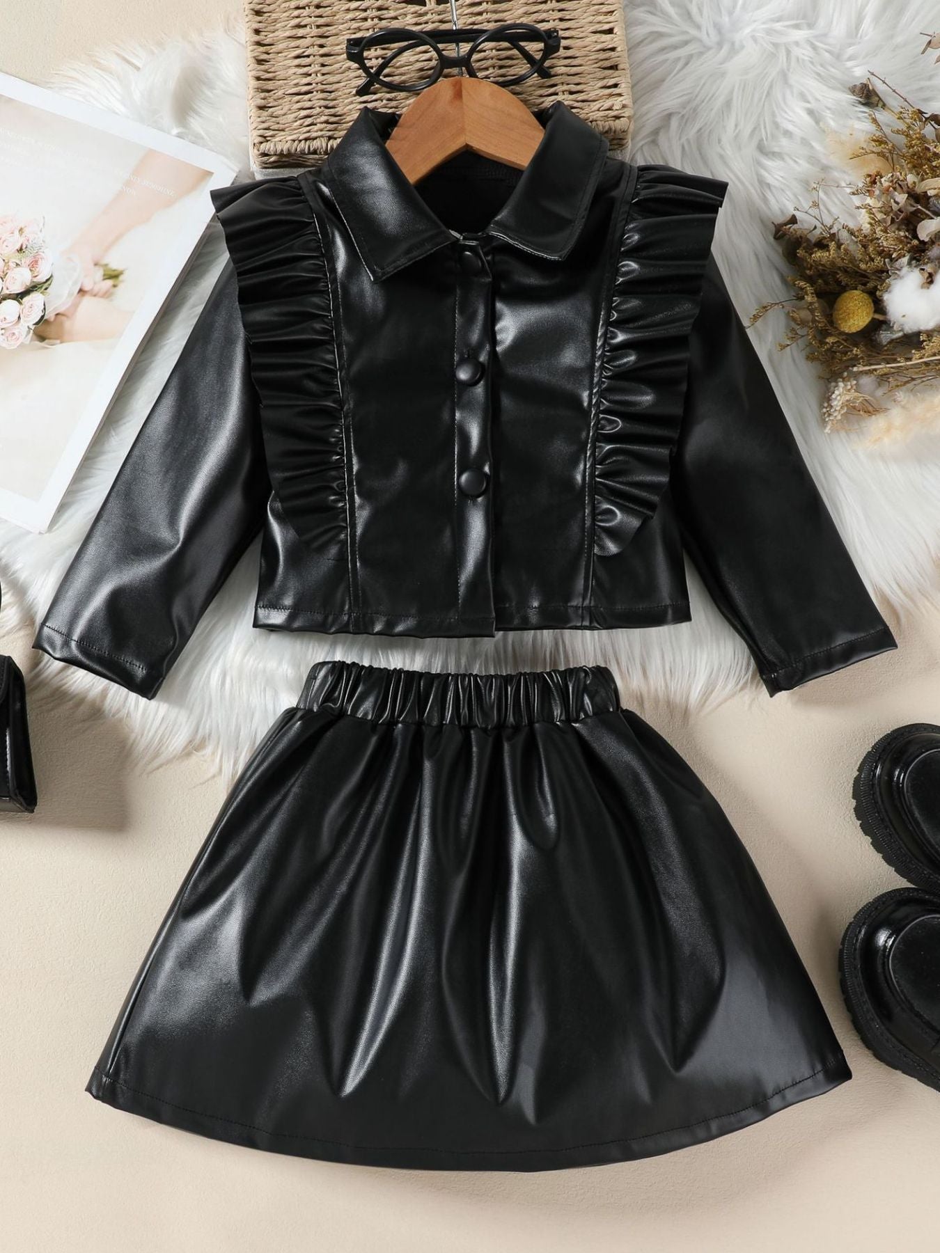 Black faux leather toddler set with ruffled collared jacket and elastic waist skirt.