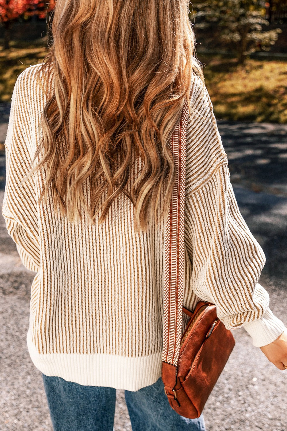 Camel and white striped drop-shoulder knit sweater with a crew neck and long sleeves.
