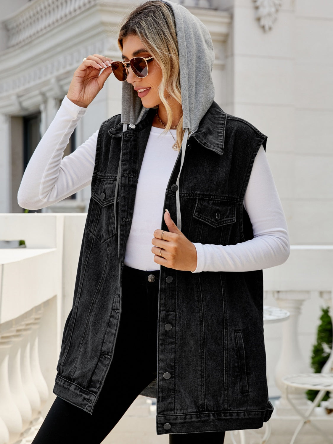 Black hooded denim vest with button-down closure and chest pockets.