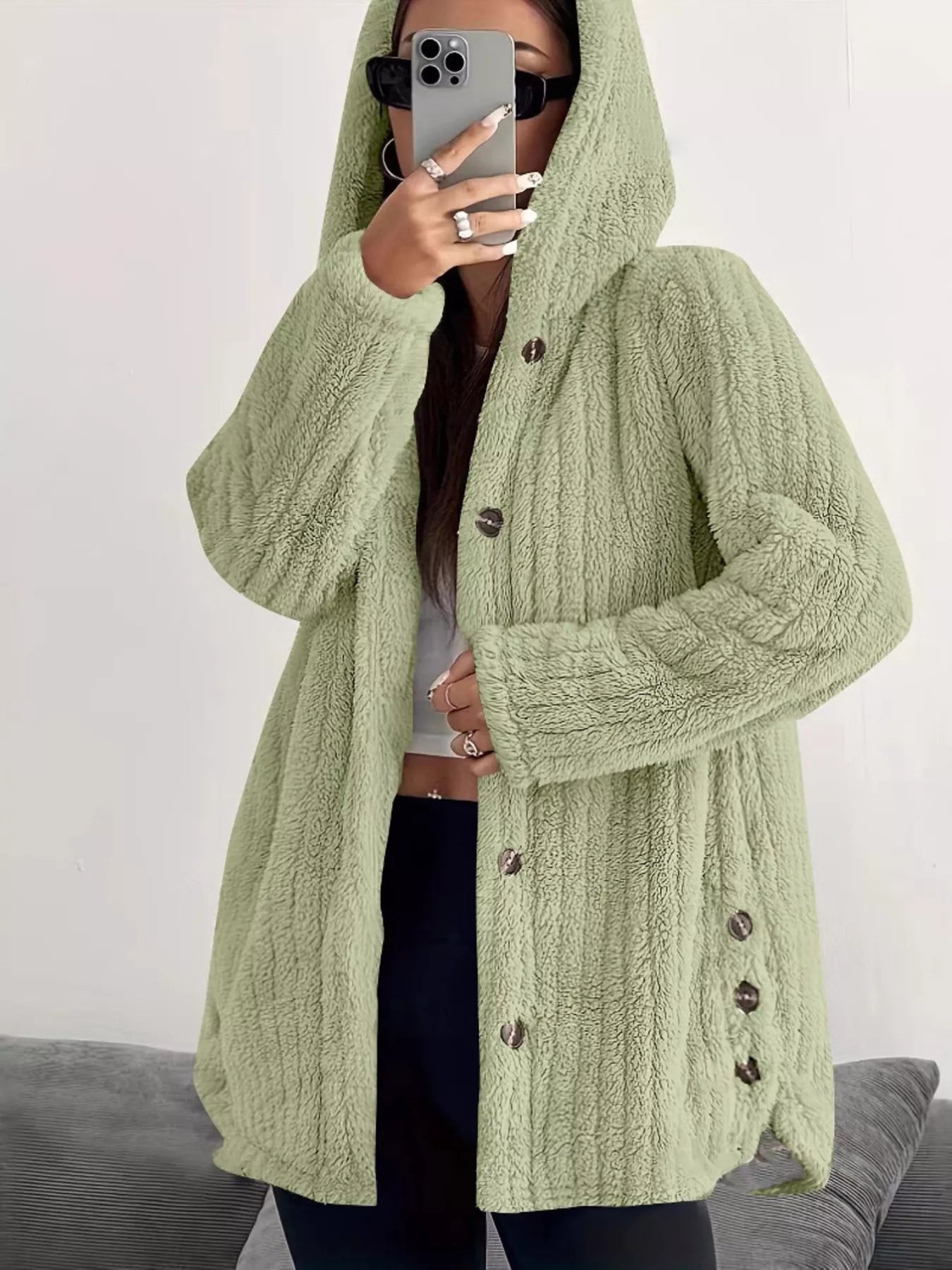 Green button-up fleece jacket with hood and textured fabric.