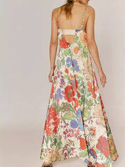 Maxi dress in ivory with a vibrant floral print, spaghetti straps, and open back detail.