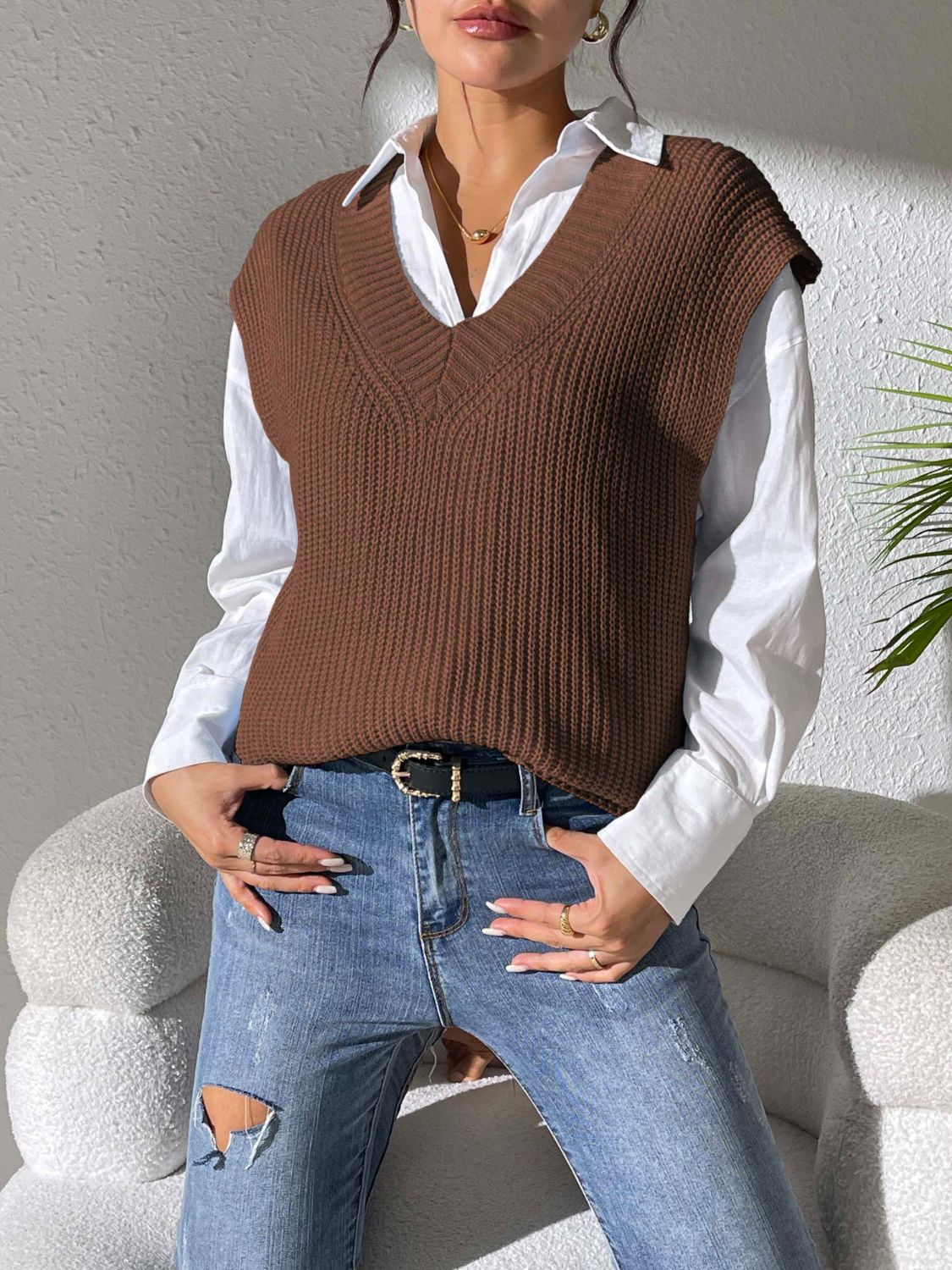 Chocolate textured knit v-neck sleeveless top styled with a white shirt and jeans.
