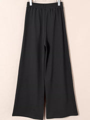 Black cotton drawstring high-waisted pleated maternity pants with a wide leg