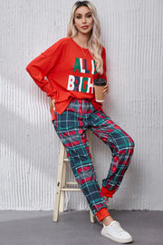 Red long sleeve top with "All Is Bright" graphic and plaid lounge pants with cuffed ankles.