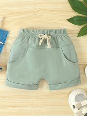 Light green cotton baby shorts with drawstring and cuffed hem.