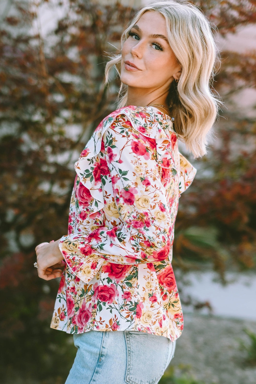 Multicolor floral ruffle smocked yoke blouse with long bell sleeves.