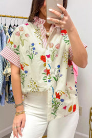 Charming floral print button-front shirt with ruffled collar and pink striped cuffs.