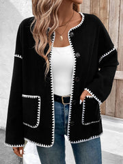 Black knit jacket with white scalloped trim and button front, featuring pockets.