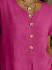 Buttoned short sleeve blouse in cerise with a v-neck and wooden buttons.