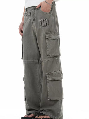 Men's grey distressed cargo pants with multiple utility pockets.
