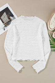 White textured long sleeve top with ruffle trim and scalloped hem