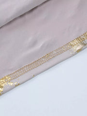 Cream maxi gown detail with abstract gold pattern and stitched hem.