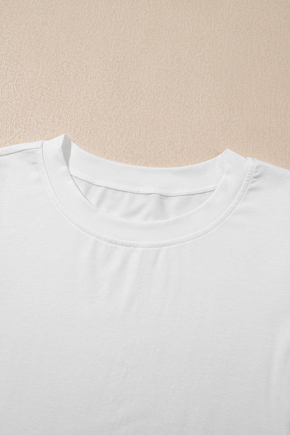 White cotton t-shirt with crew neck and visible lace inset detail on sleeve.