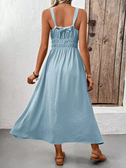 Light blue smocked midi dress with tie straps and a flowing skirt.