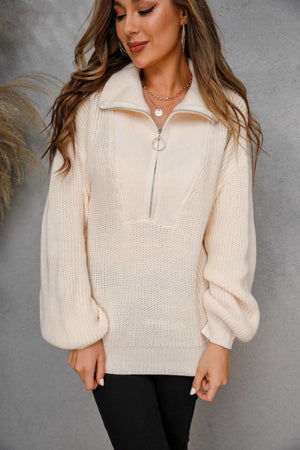 Ivory ribbed knit half-zip pullover sweater with balloon sleeves and a silver zipper.