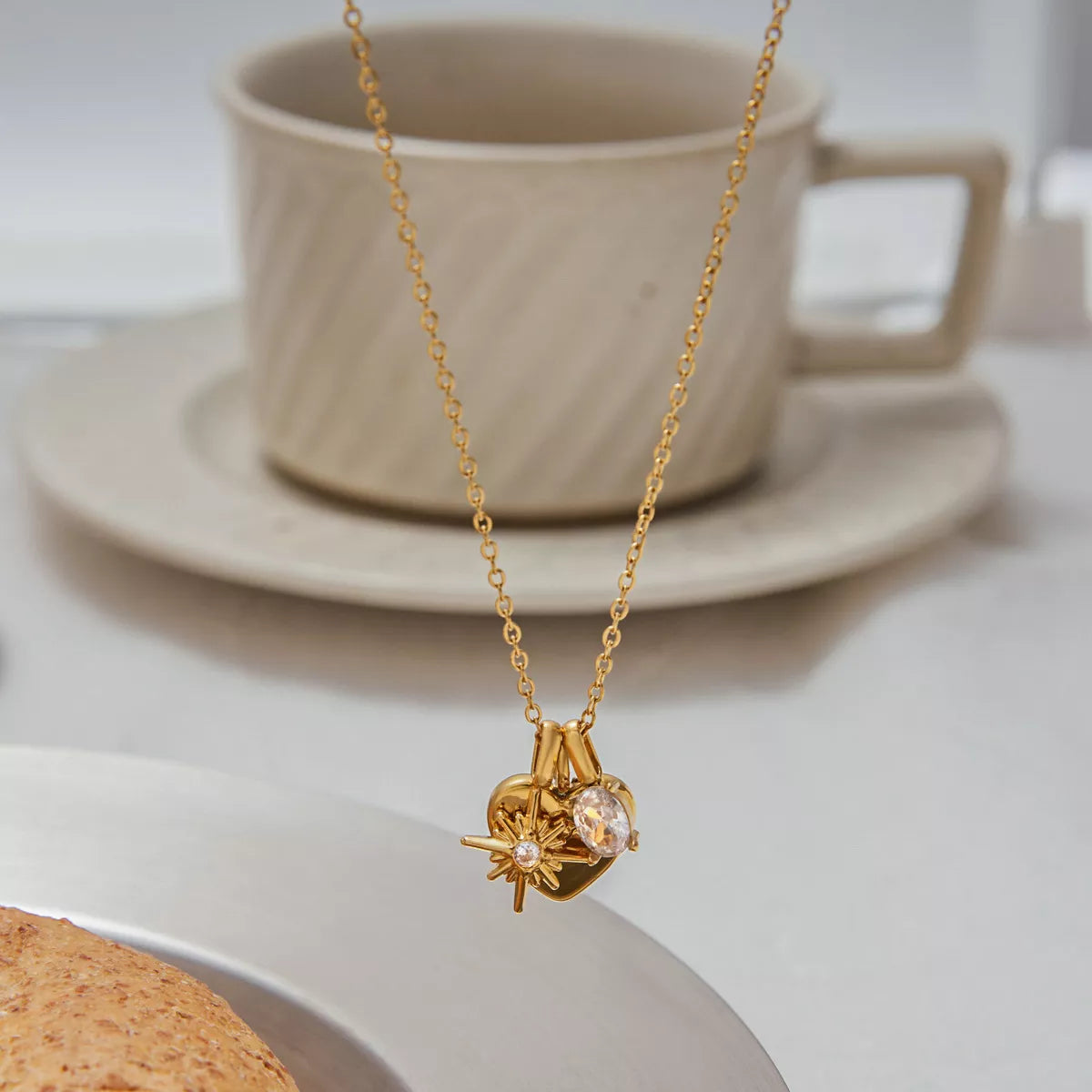 Gold heart charm necklace with crystal accent and starburst detail